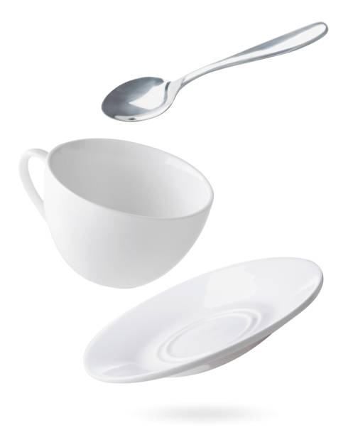 empty dishes cup, plate and spoon are flying on a white. isolated - �茶碟 個照片及圖片檔