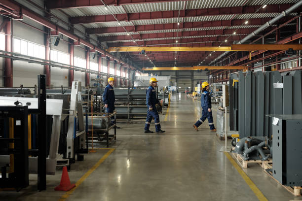 istock Factory employees in hardhats walking in line 1324567125