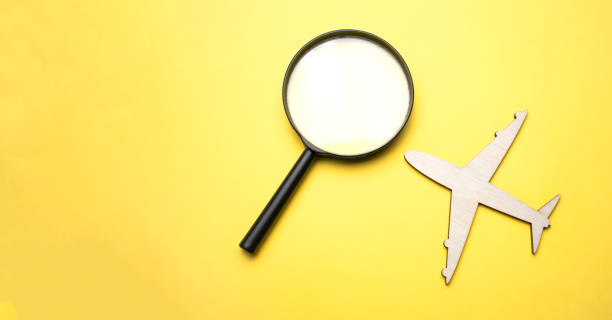 istock Travel concept. Airplane, magnifier with a globe on a yellow background. Top view. Flat lay 1324567977