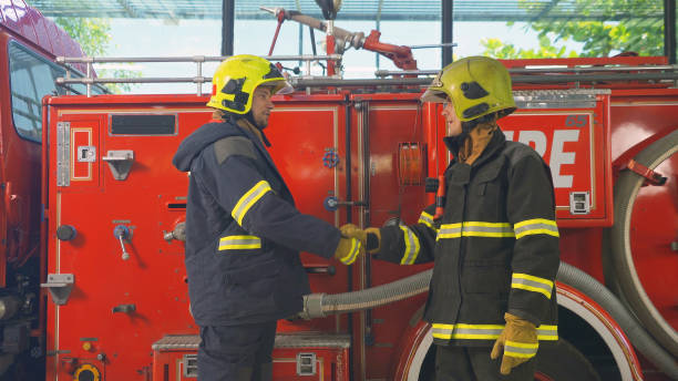 istock A successful group of caucasian firefighters or firemen team with uniform shaking hands, working on their career. An emergency accident rescue. People. Hero teamwork with a fire truck car. Service job 1324569022