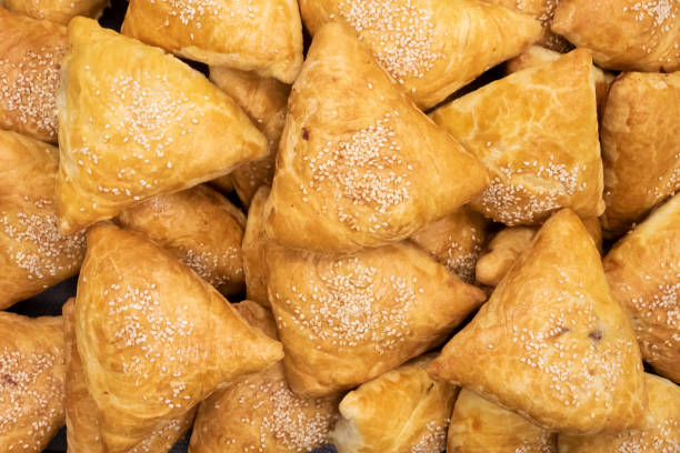 istock Baked samosas sprinkled with sesame seeds, top view 1324572465
