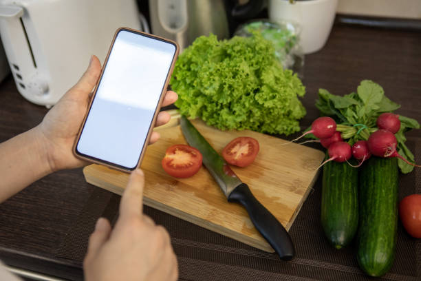 istock holding phone with white screen cooking fresh salad 1324572589