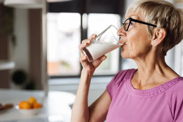 Photo of Mature woman drinking fresh milk from a glass