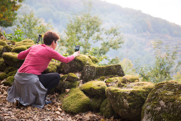 istock Short-haired woman crouching next to stone wall 1324575976