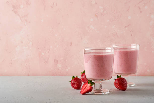 two strawberry smoothie or milkshake with berries and mint in glass on light pink background. summer drink shake, milkshake and refreshment organic concept. healthy dieting, vegetarian food concept. - vitality food food and drink berry fruit imagens e fotografias de stock