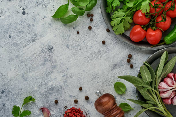 istock Food cooking background. Fresh saffron, garlic, cilantro, basil, cherry tomatoes, peppers and olive oil, spices herbs and vegetables at light grey slate table. Food ingredients top view. 1324580452