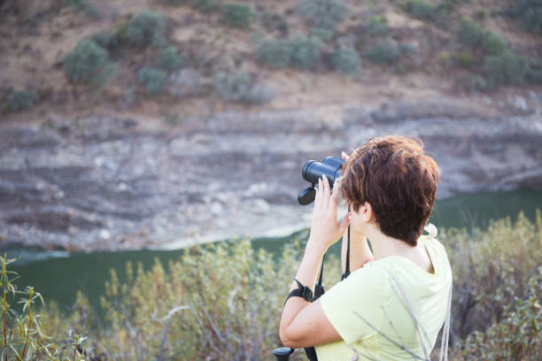 istock Short-haired woman observing through binoculars 1324580497