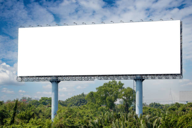 blank billboard on the sideway in the park. image for copy space, advertisement, text and object. white billboard in natural green. stock photo