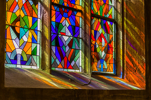 Sunlight pouring through stained glass windows of a church in Kaysersberg France