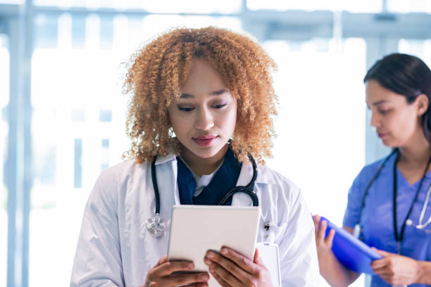 istock Medical doctor wearing white coat has solemn face while looking at digital tablet 1324582727