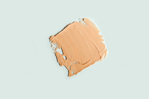 Facial concealer strokes BB or CC cream foundation on light blue background. Facial concealer strokes BB or CC cream foundation on light blue background. Close-up of liquid foundation, texture of a makeup product. liquid foundation face stock pictures, royalty-free photos & images