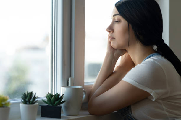istock Woman looking out the window 1324583319