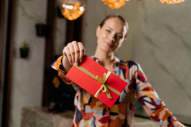 garota com cartão de presente. mulher segurando cupom de certificado vermelho - presente para feriados. - 264 - fotografias e filmes do acervo