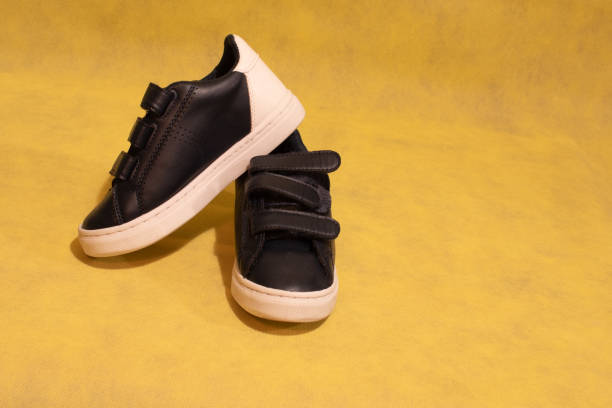 istock blue sneakers with velcro fastening on yellow background and copy space 1324585264