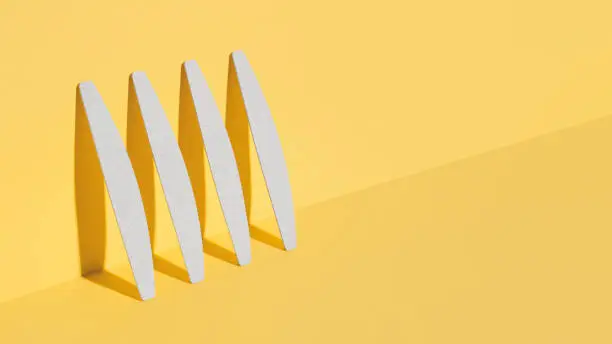 Set of nail files, emery board for nails of different shapes and different stiffness on a yellow background. isometric diagonal projection. Minimal, Trendy shadows, Modern photo.Mock up for manicurist