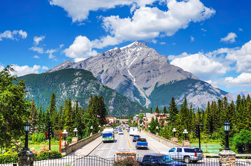 Busy Banff Avenue inside Banff National Park with Cascade Mountain in the background. The town is a major Canadian tourist destination renowned for its mountainous surroundings and hot springs.