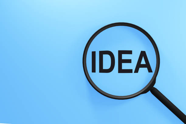 istock The word idea on blue screen through magnifying glass. 1324596082