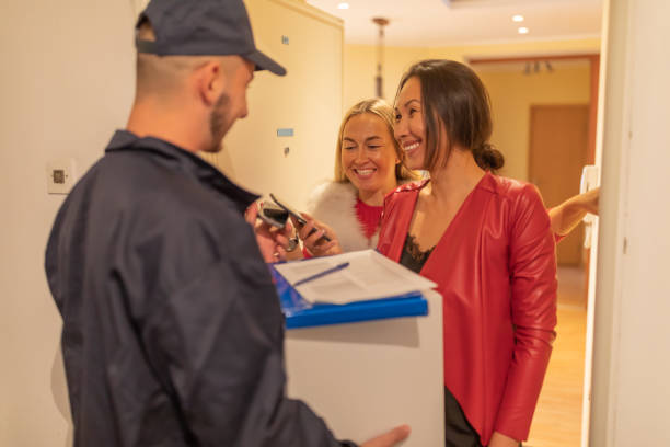 istock Young Courier is Delivering Package to Two Women. 1324596250