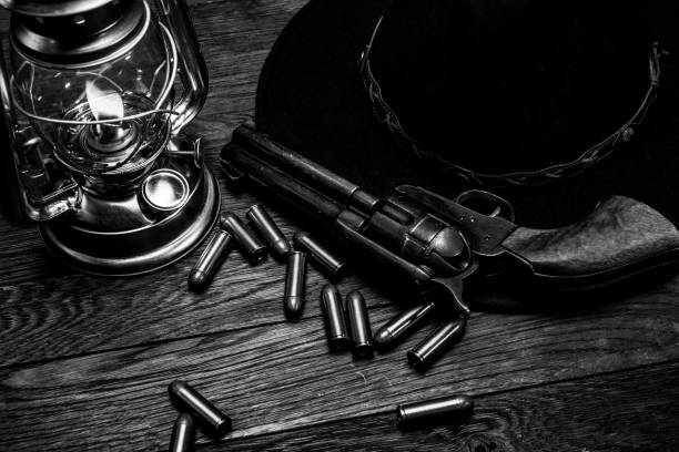 istock Revolver gun with cartridges on table with cold blast lantern and black hat 1324601562