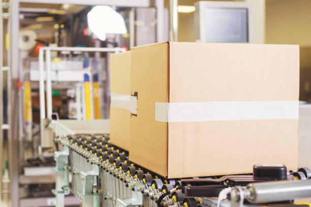 istock Sealed cardboard box on a conveyor belt in a factory 1324602237