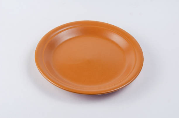 istock Brown round clay plate on white background. Kitchen utensils mad 1324610121