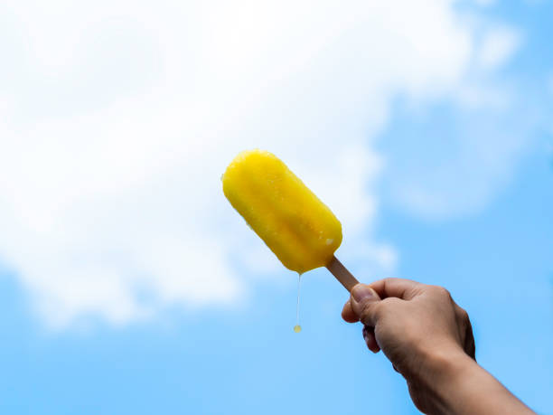 istock Yellow popsicle in happy smiling beautiful Asian woman's hand. 1324617075