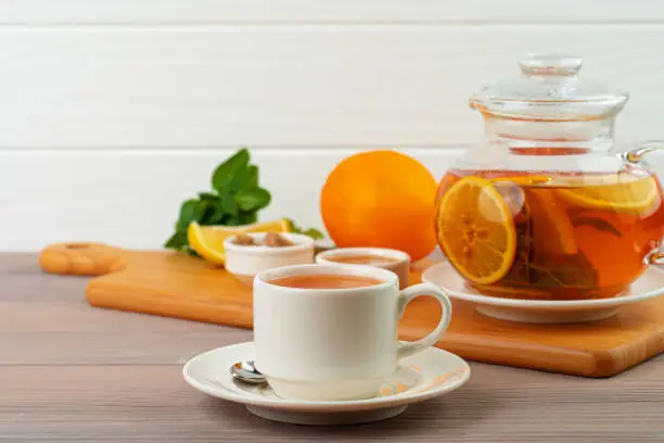 Cup of tea served with lemon and mint close up