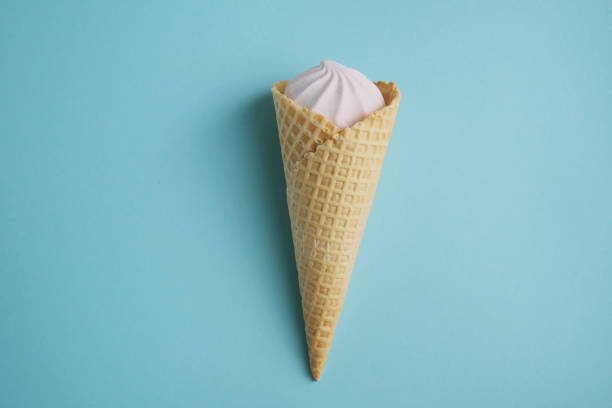 istock Sugar waffle tube with marshmallows, cremo on a blue background. 1324625364