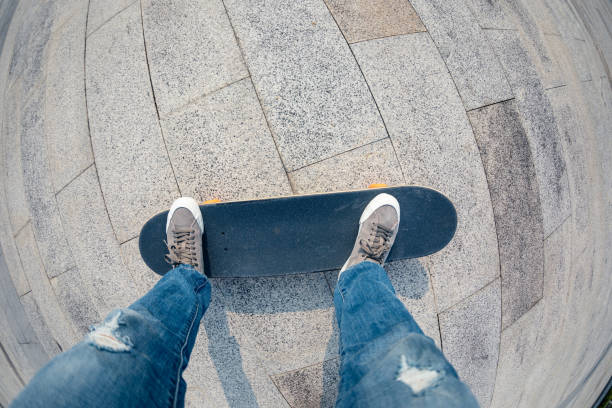 The picture shows a young boy standing on a skateboard practiced on a concrete floor.