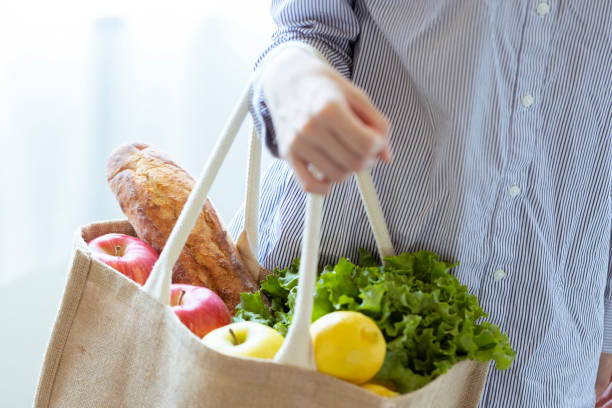 mano de una mujer con verduras y pan con bolsa eco - shopping bag fotos fotografías e imágenes de stock