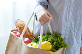 エコバッグ付き野菜とパンを持つ女性の手