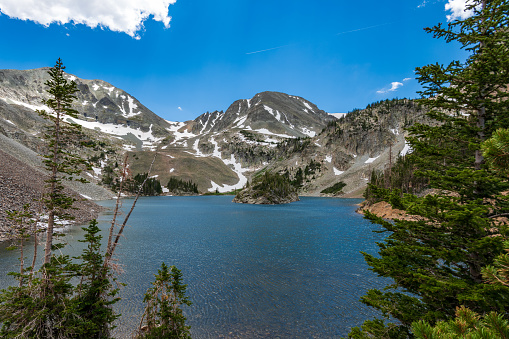 Blue-green water, green spruce and blue sky at Agnes Lake in State Forest State Park