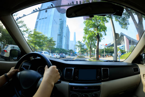 istock People hands holding steering wheel while driving car in modern city 1324627170