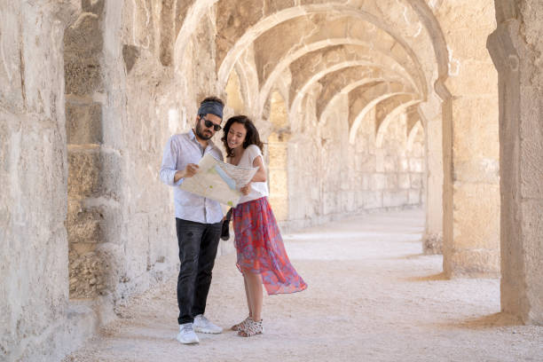 istock Young couple checking city map while traveling at Aspendos Amphitheater, Antalya, Turkey 1324630558
