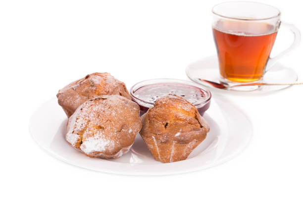 Cup of tea and muffins. Isolated over white background. Close-up.