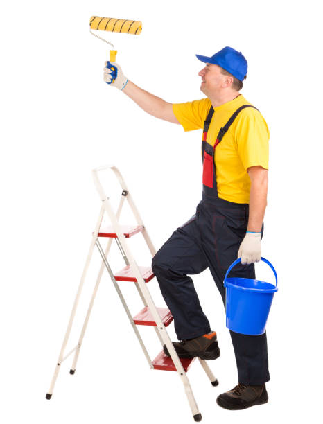 istock Worker on the stairs with a paint roller and a bucket. 1324632107