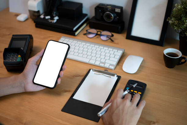 istock Businessman holding smart phone and using calculator at office desk. 1324636760