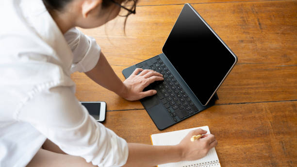 istock Young woman student sitting in living room and using computer tablet. 1324636831