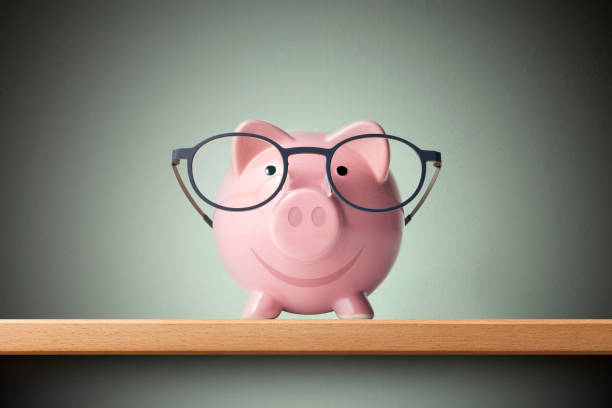 istock Piggy bank with glasses on shelf 1324640162
