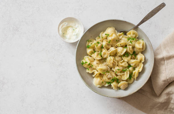 istock Boiled dumplings( Russian traditional food-pelmeni)  in gray bowl on gray stone background 1324640193