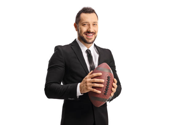 istock Young man in a suit and tie holding a rugby ball 1324641108