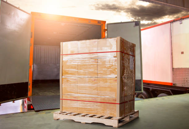istock Stacked of Package Boxes on Pallet Load with Cargo Container. Trucks Parked Loading at Dock Warehouse. Delivery Service. Shipping Warehouse Logistics. Road Freight Truck Transportation. 1324642068