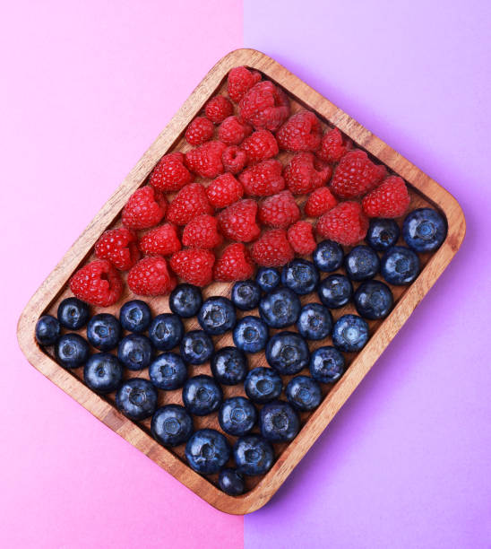istock Raspberries and blueberries on a wooden tray 1324644270