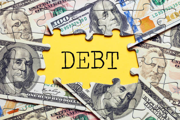 istock The word debt surrounded by puzzle pieces with dollar bills. Bus 1324645225