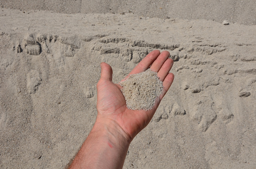 hands with sand at the sea