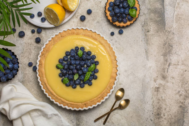 istock Blueberry and lemon curd tart on grey stone table. Top view. Copy space. 1324648522