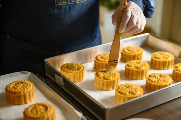 Moon cake baker brushing egg liquid on top prepare for bake