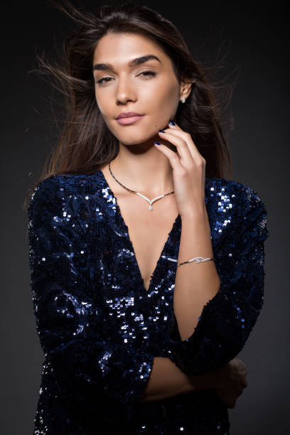 dark studio portrait of a beautiful young woman against white backgroung.