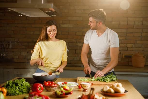 istock Happy couple talking while making lunch in the kitchen. 1324650353