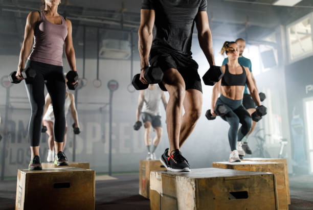 istock Athletic people having cross training with dumbbells in a gym. 1324650389
